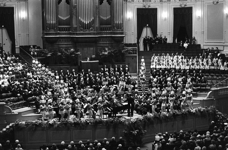 Koor op het podium met dirigent, Bestanddeelnr 924-3338