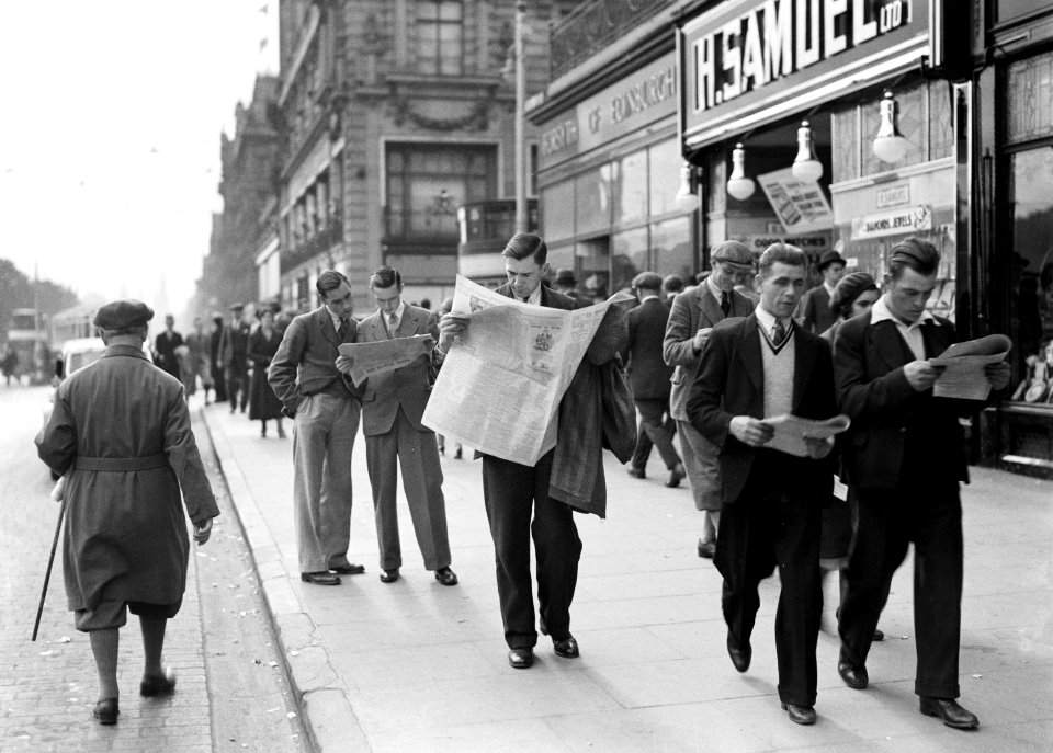 Kranten lezende mannen op het trottoir, Bestanddeelnr 252-1267