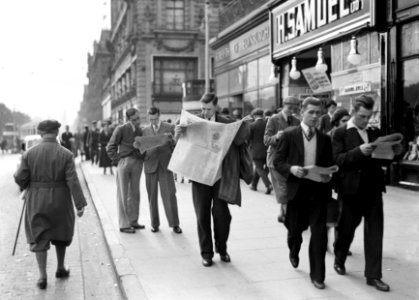 Kranten lezende mannen op het trottoir, Bestanddeelnr 252-1267