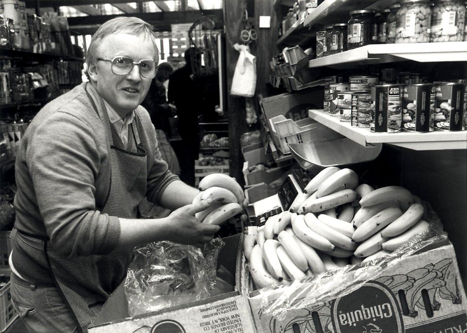 Kruidenier M. van Schie in de Nassaustraat 24. Aangekocht in 1989 van United Photos de Boer bv. - Negatiefnummer 29015 k 23 a. - Gepubliceerd in het Haarlems Dagblad van 06-05-1988. Identificatienumme