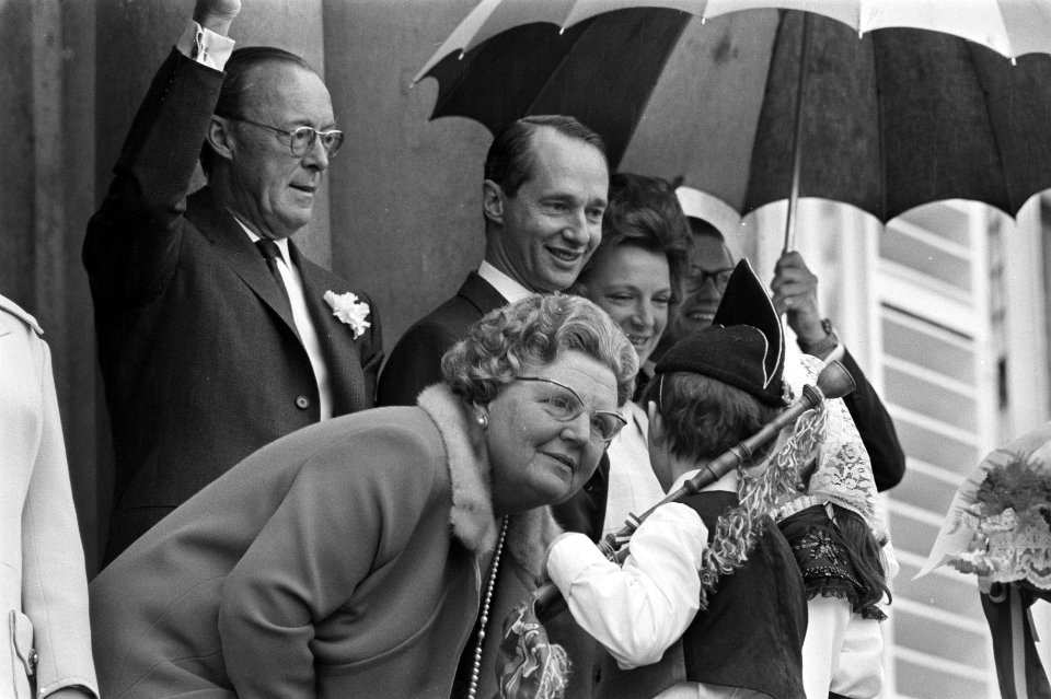 Koningin Juliana begroet een jeugdige deelnemer aan het defilé, Bestanddeelnr 923-4859