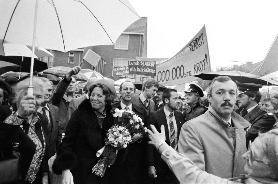 Koningin Beatrix wandelt tussen het publiek. Op de achtergrond een protestspando, Bestanddeelnr 932-3533