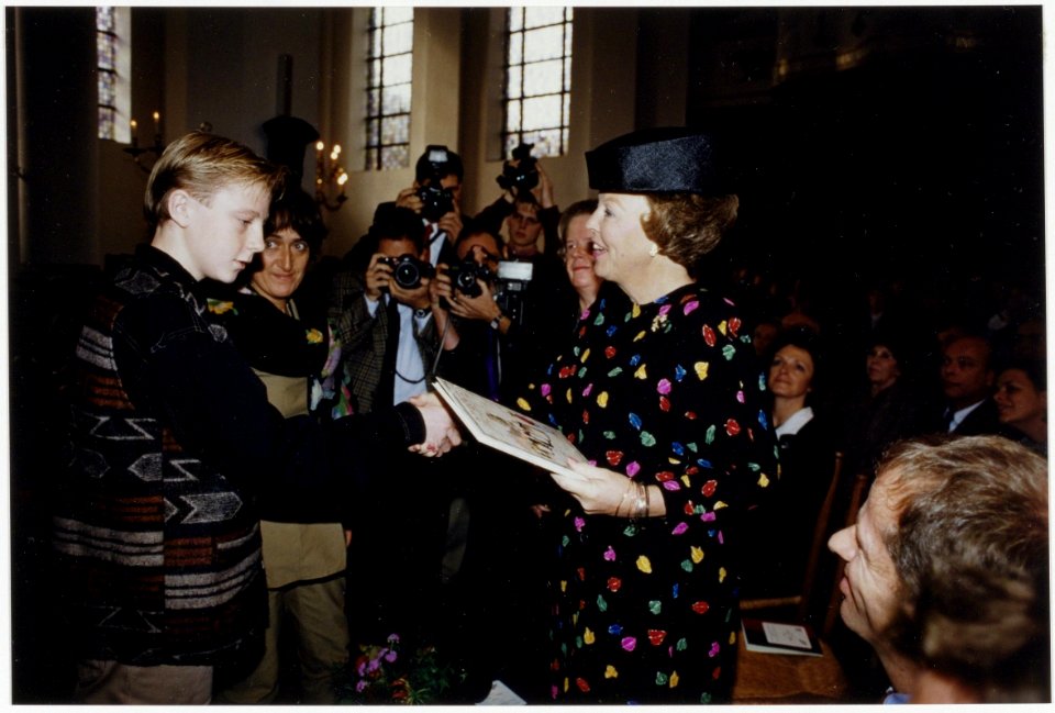 Koningin Beatrix ontvangt in de Nieuwe Kerk het boek In Haarlem staat een huis, een door Clara Brinkgreve geschreven jubileumuitgave van het Coen Cuserhuis