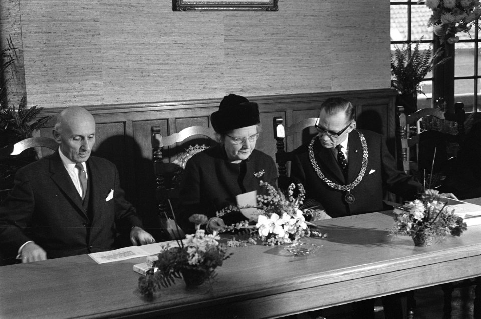 Koningin Juliana in een raadzaal, naast haar burgemeester ..., Bestanddeelnr 915-8313