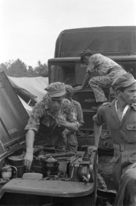 KNIL-militairen kijken onder een motorkap, Bestanddeelnr 108-6-3
