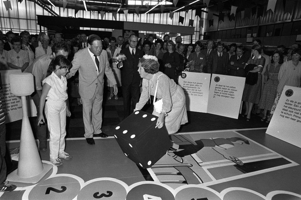 Koningin Beatrix gooit een dobbelsteen van het gezondheidsspel op de Nederland O, Bestanddeelnr 931-6487