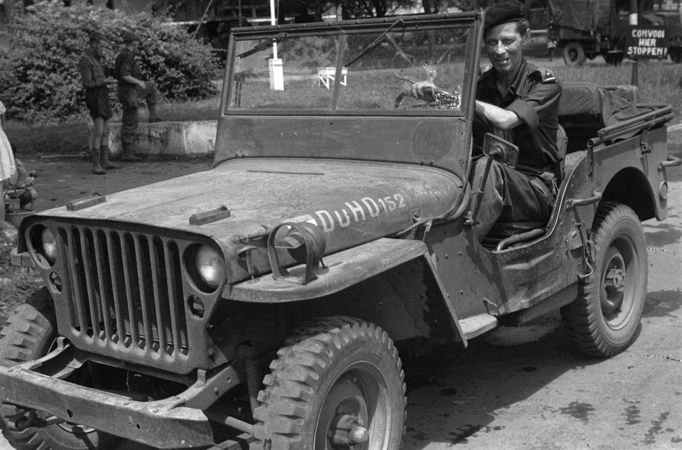 KNIL-majoor achter stuur van jeep, met kogelgat in voorruit., Bestanddeelnr 5910