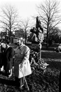Koko Petalo, de zigeunerkoning (met stok), met op de achtergrond het monument, Bestanddeelnr 930-5556