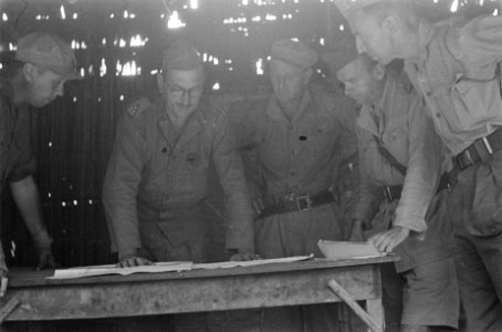 Kolonel F. Mollinger overlget met stafofficieren gebogen over een tafel met kaar, Bestanddeelnr 339-3-1