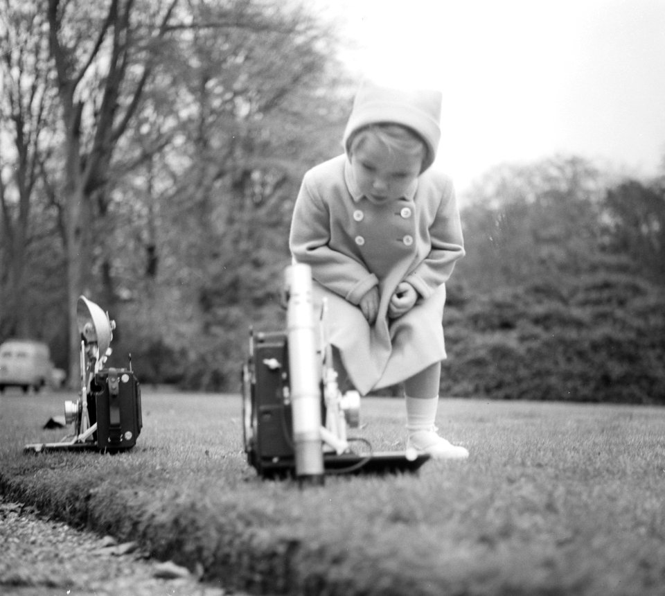 Koninklijk gezin op Soestdijk. In de paleistuin. Prinses Marijke bekijkt de foto, Bestanddeelnr 904-2811