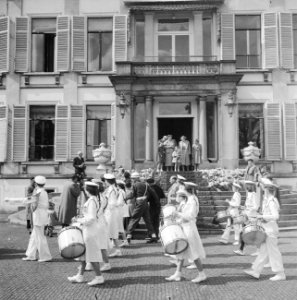 Koninklijk gezin kijkt naar de voorbij trekkende delegatie muziekkorps, Bestanddeelnr 934-5475