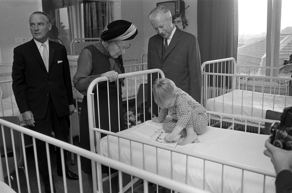 Koningin Juliana bij een patiëntje, naast Hare Majesteit geneeskundig directeur , Bestanddeelnr 925-0230