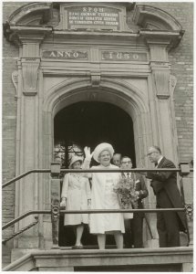 Koningin Juliana bezoekt Haarlem en zwaait vanaf het bordes van het stadhuis. NL-HlmNHA 54011901 1