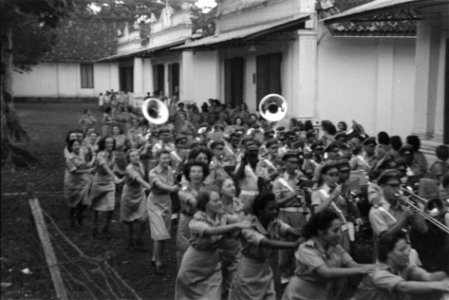 Leden Vrouwenkorps KNIL dansen een polonaise onder begeleiding van Stafmuziek KN, Bestanddeelnr 223