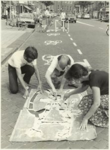 Leden van de Fietsersbond voeren actie op de Gedempte Oude Gracht middels het aanbrengen van klinkerprints om het fietspad te markeren. NL-HlmNHA 54021142