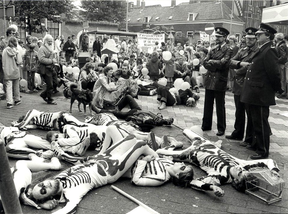 Leden van de Vereniging Dienstweigeraars voerden tijdens de Vredesmars en luguber schouwspel op, zij brachten de naargeestige gevolgen van een bominslag in beeld, op de hoek van de Smedestra, NL-HlmNHA 54012372