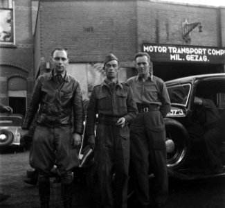 Leden Binnenlandse Strijdkrachten te Arnhem voor een garage van een Motor Trans, Bestanddeelnr 900-4393