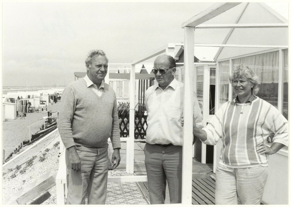 Leden van de kampeervereniging Helios bij hun strandhuisjes. NL-HlmNHA 54005823