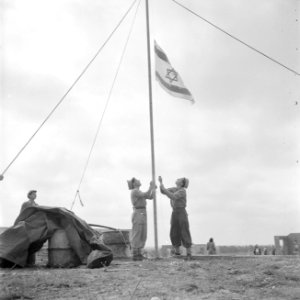Leden van de bouwploeg van moederkibboets Yavne hijsen de Israëlische vlag, Bestanddeelnr 255-0717