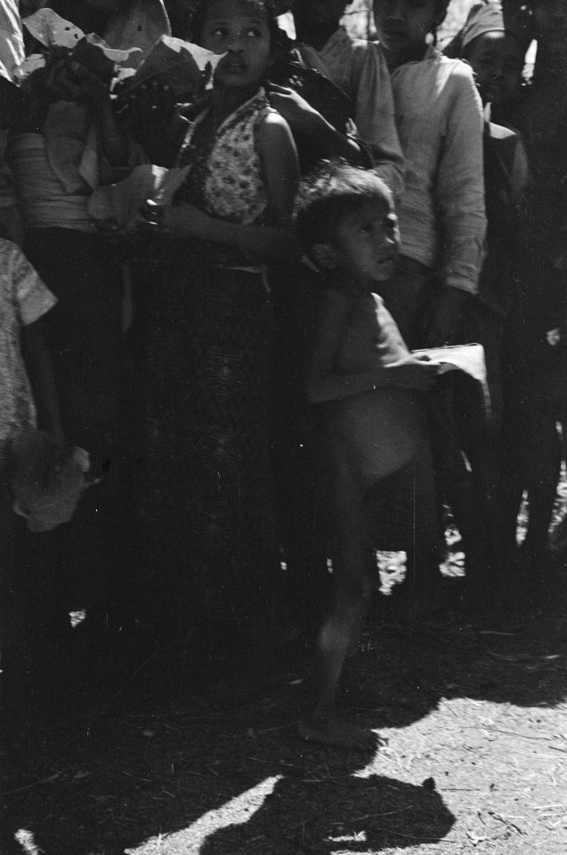 Lange rij Indonesiërs voor een veldkeuken. Kinderen staan vooraan. Jongen met ho, Bestanddeelnr 346-4-5