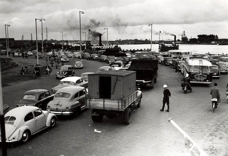 Lange rijen wachtende auto's voor de Pont, om over het Noordzeekanaal gezet te worden, ziende naar het zuidoosten. Aangekocht in 1976 van Fotopersbureau de Boer, NL-HlmNHA 1478 25900 K 38