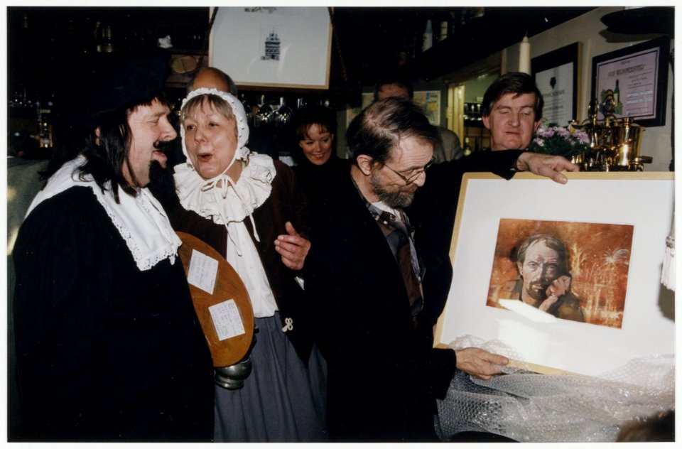 Lennaert Nijgh pakt het schilderij met zijn portret uit, op de presentatie van zijn boek Haarlem bestaat niet in de Waag. Links achter hem Josée Koning en rechts directeur Ben Essenberg va, NL-HlmNHA 54036447
