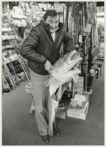 Leo Balk poseert met zijn in IJmuiden gevangen kabeljauw, in de Hengelsportwinkel van Paul Goedvolk aan de Botermarkt