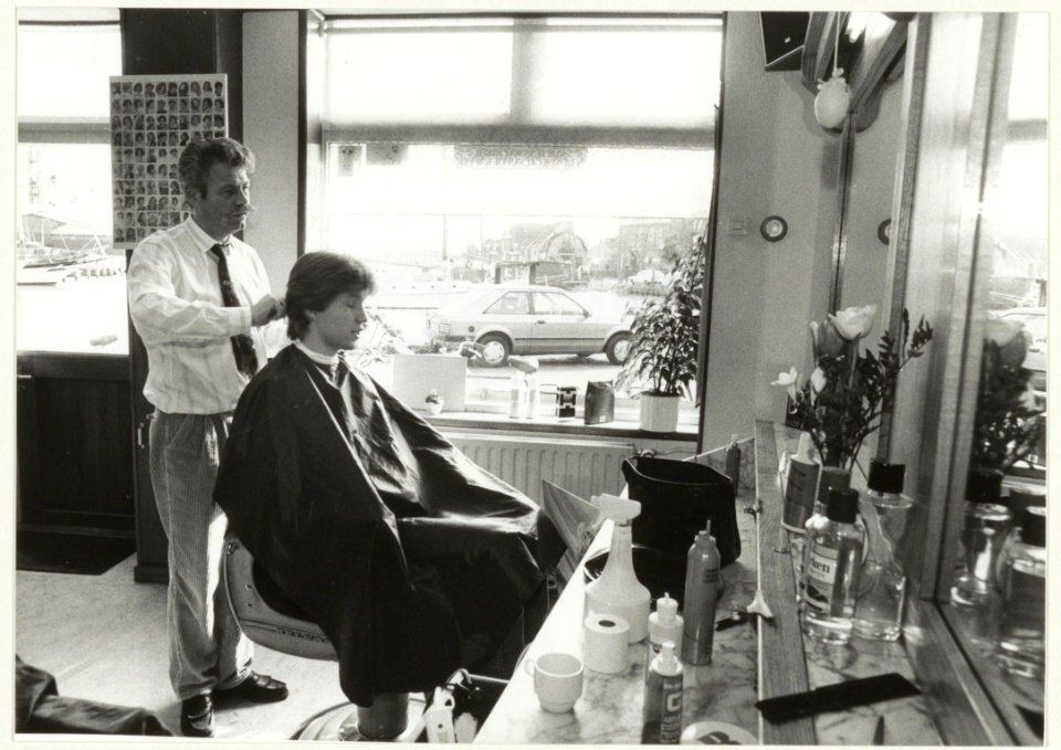 Leo van der Wiel in zijn kapsalon aan de Taanplaats 28 in Spaarndam. Foto ter gelegenheid van het 25-jarig jubileum. NL-HlmNHA 54031503