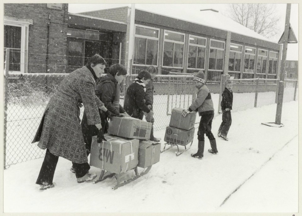 Leerlingen met voedsel- en kledingpakketten op weg naar de Godfried Bomansschool waar een bliksemaktie voor de Poolse stad Olsztyn wordt gehouden. NL-HlmNHA 54013130