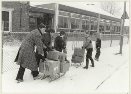 Leerlingen met voedsel- en kledingpakketten op weg naar de Godfried Bomansschool waar een bliksemaktie voor de Poolse stad Olsztyn wordt gehouden. NL-HlmNHA 54013130