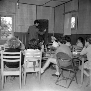 Leerlingen en een leerkracht in een leslokaal van het kinderdorp Oniem, Bestanddeelnr 255-0520