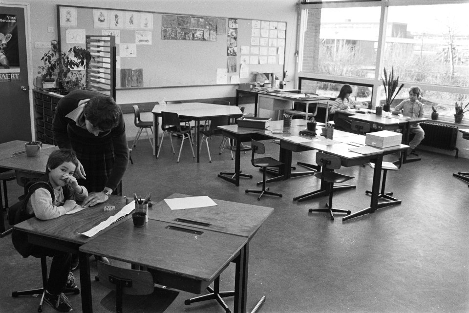 Leerkracht en kinderen in een vrijwel lege klas, Bestanddeelnr 932-7976