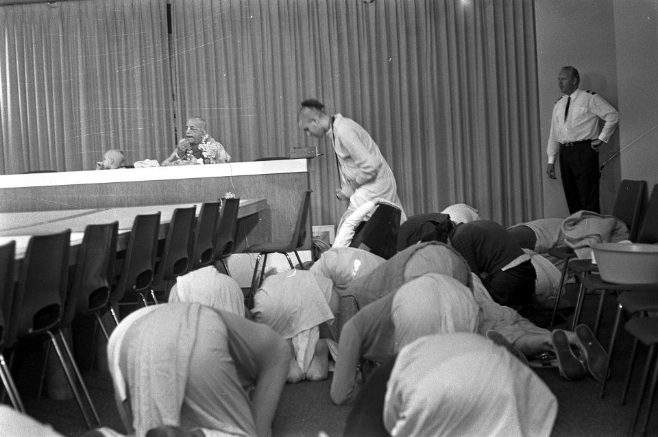 Leider van Hare Krishna beweging op Schiphol, volgelingen in gebed, Bestanddeelnr 925-7729