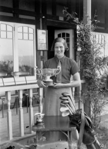Lady holding a trophy outside Llandrindod Wells Golf Club pavilion (1294292)