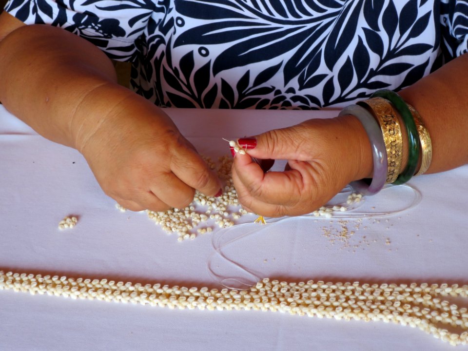 Lady from Niihau making a shell lei