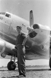 Lachende militair staat bij een propeller van een vliegtuig, Bestanddeelnr 37-3-2