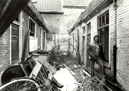 Lange Annastraat 12, Karl Svoboda in de Koopallepoort Bakken vuil heb ik al uit deze steeg gehaald, maar de rotzooi blijft komen. Aangekocht in 1977 van fotograaf C. de Boer, NL-HlmNHA 54005082