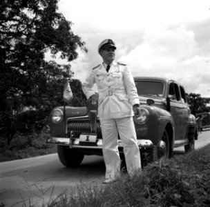 Luitenant-kolonel W.K. Boogh bij een auto met standaard in Paramaribo. De auto h, Bestanddeelnr 252-6325