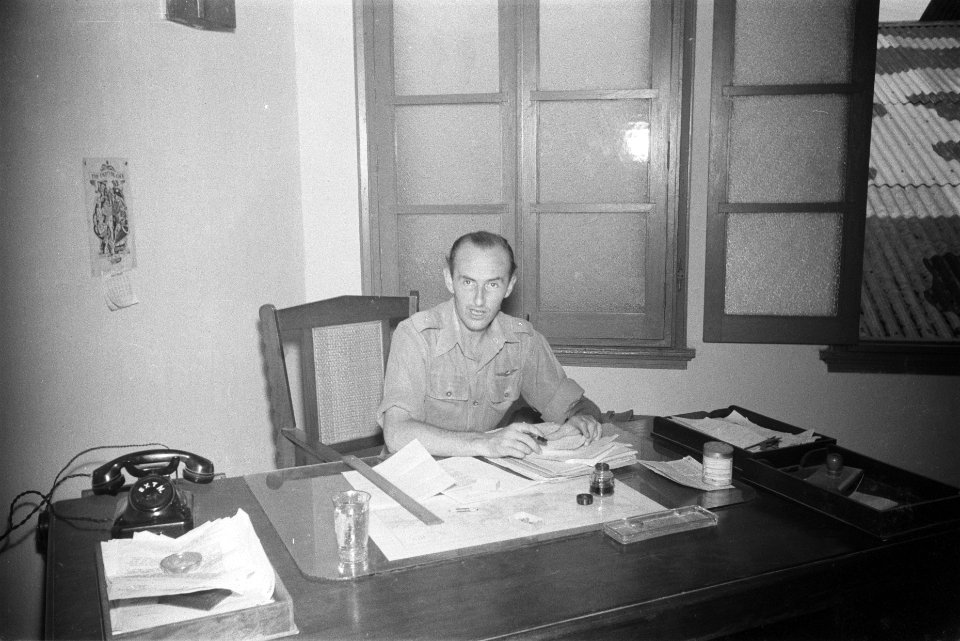 Luitenant achter een bureau in het kantoor van Dienst Welfare, Bestanddeelnr 110-2-4