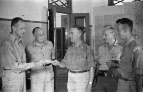 Luitenant-kolonel D. Huiting krijgt iets uitgereikt. Om hem heen vier mannen i…, Bestanddeelnr 450-1-4