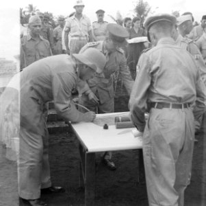 Luitenant-gouverneur-generaal H.J. van Mook tekent met een ganzenveer een oorko, Bestanddeelnr 6971