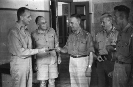 Luitenant-kolonel D. Huiting krijgt iets uitgereikt. Om hem heen vier mannen i…, Bestanddeelnr 450-1-3