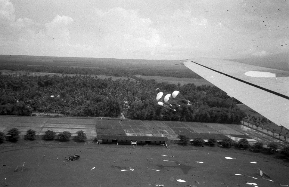 Luchtopname. Sportveld. In de lucht hangen parachutes met voorraden. Op het vel, Bestanddeelnr 2716