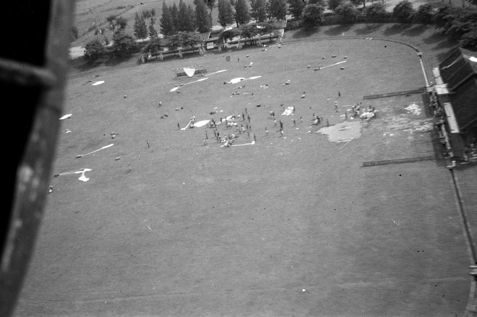 Luchtopname Sportveld Op het veld liggen parachutes De gedropte voorraden wo, Bestanddeelnr 2718