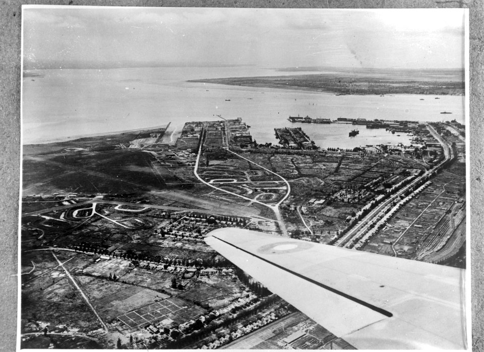 Luchtfoto van een vliegveld aan zee en een havengebied, Bestanddeelnr 935-3392