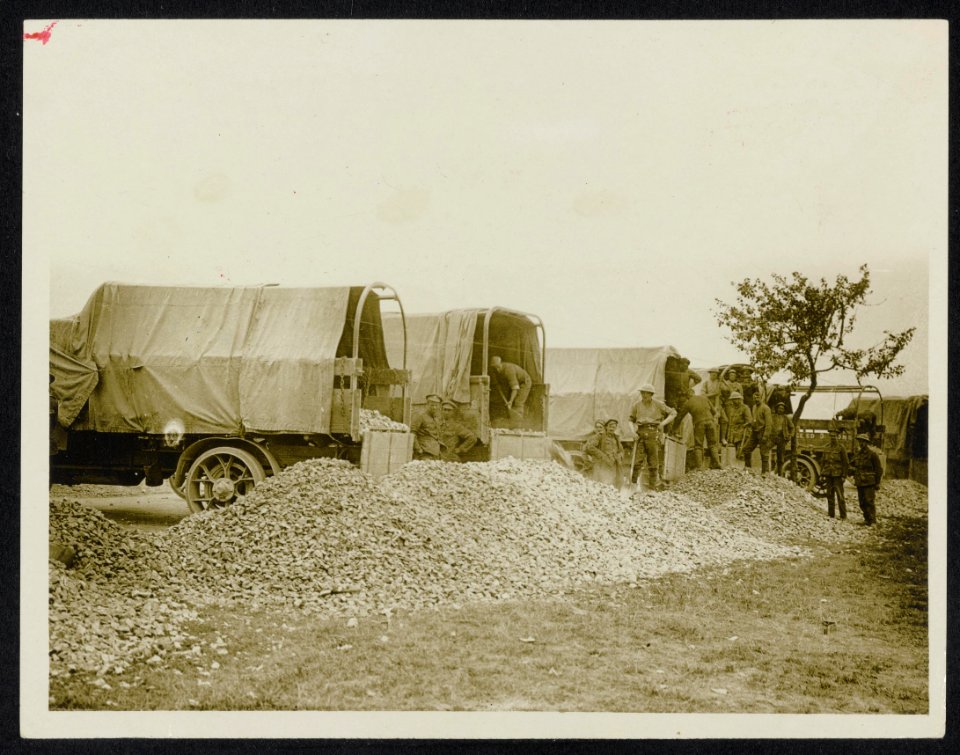 Lorries unloading stones to make up the roads as we advance, Bestanddeelnr 158-0907