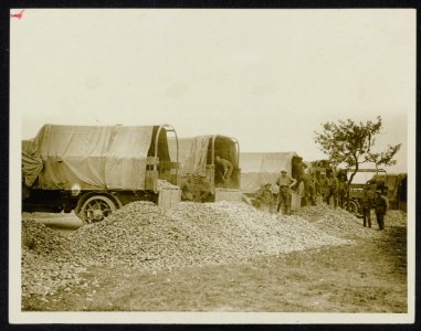 Lorries unloading stones to make up the roads as we advance, Bestanddeelnr 158-0907
