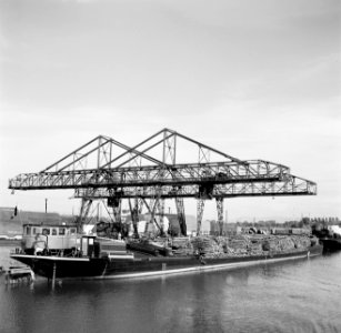 Lossen van een binnenvaartschip met hout bij een papierfabriek, Bestanddeelnr 254-1199