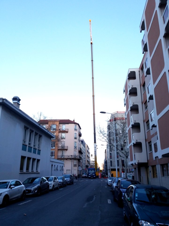 Lyon 6e - Rue Germain, grue mobile à flèche télescopique démontant la grue du chantier de l'immeuble à l'angle de la rue Bellecombe