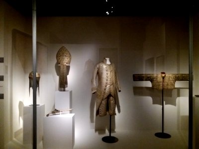 Lyon 2e - Musée des Tissus et des Arts décoratifs, vitrine avec mitre, casque, pistolet, habit et veste